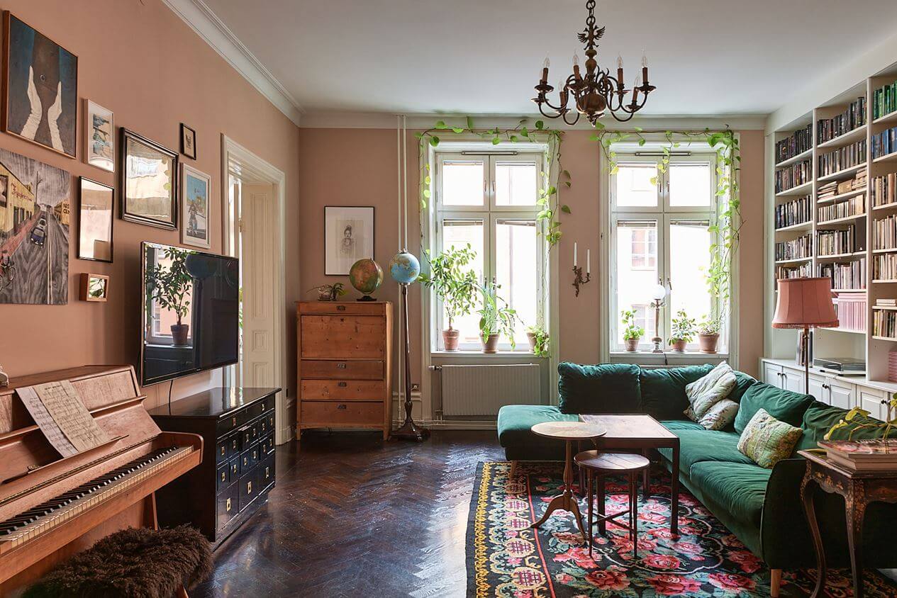 romantic-living-room-pink-walls-green-sofa-bookshelves-nordroom