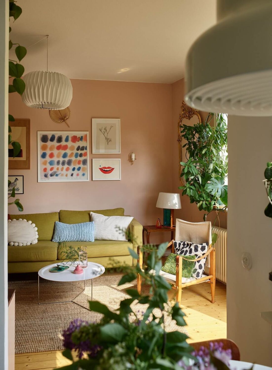 green sofa pink walls plants studio apartment nordroom
