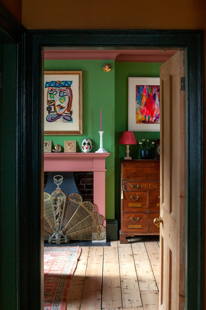 living-room-wooden-floorboards-pink-fireplace-green-walls-nordroom