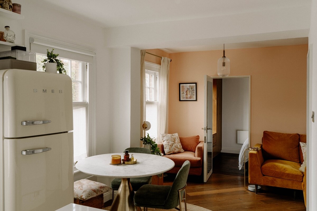 small open plan living room pink wall round dining table