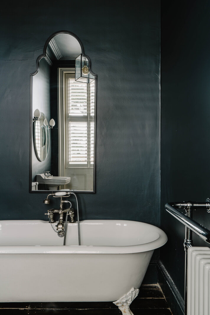 dark blue victorian bathroom with wooden floor and clawfoot bath nordroom