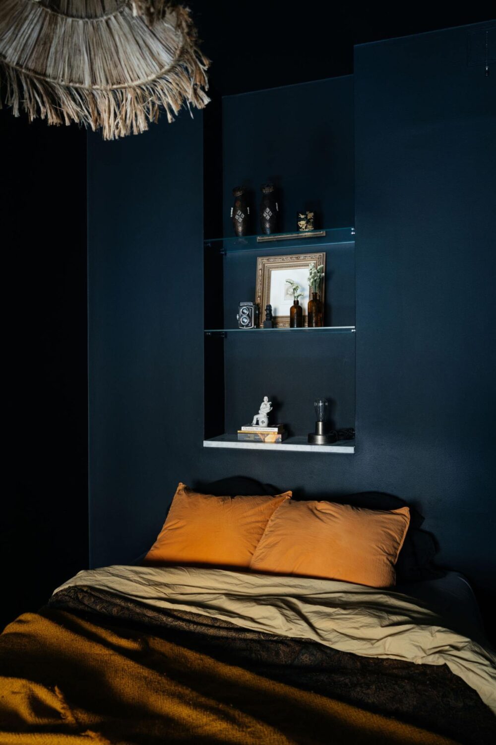 small dark blue bedroom with earthy colored bedding nordroom