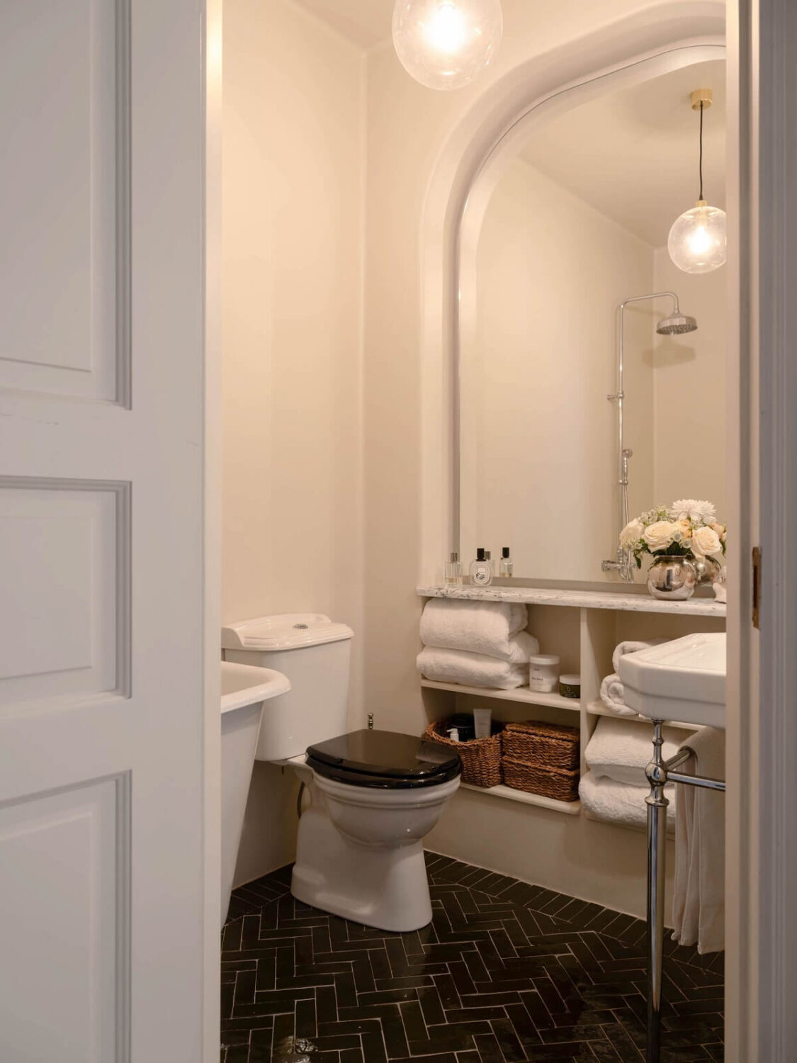 bathroom with black floor tiles and large mirror