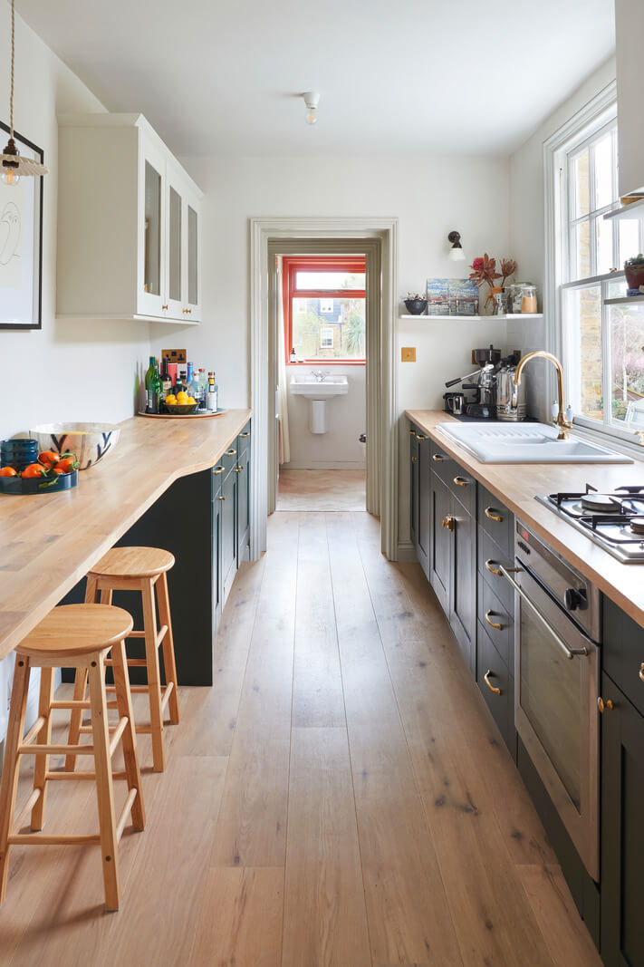 galley kitchen with green cabinets and bar seating