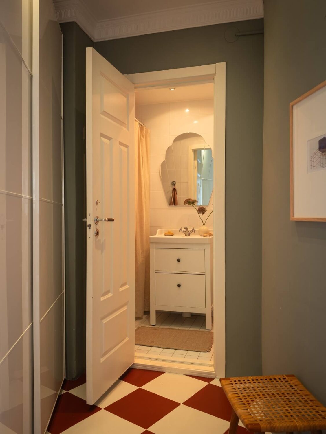 hallway with checkerboard floor and view of bathroom