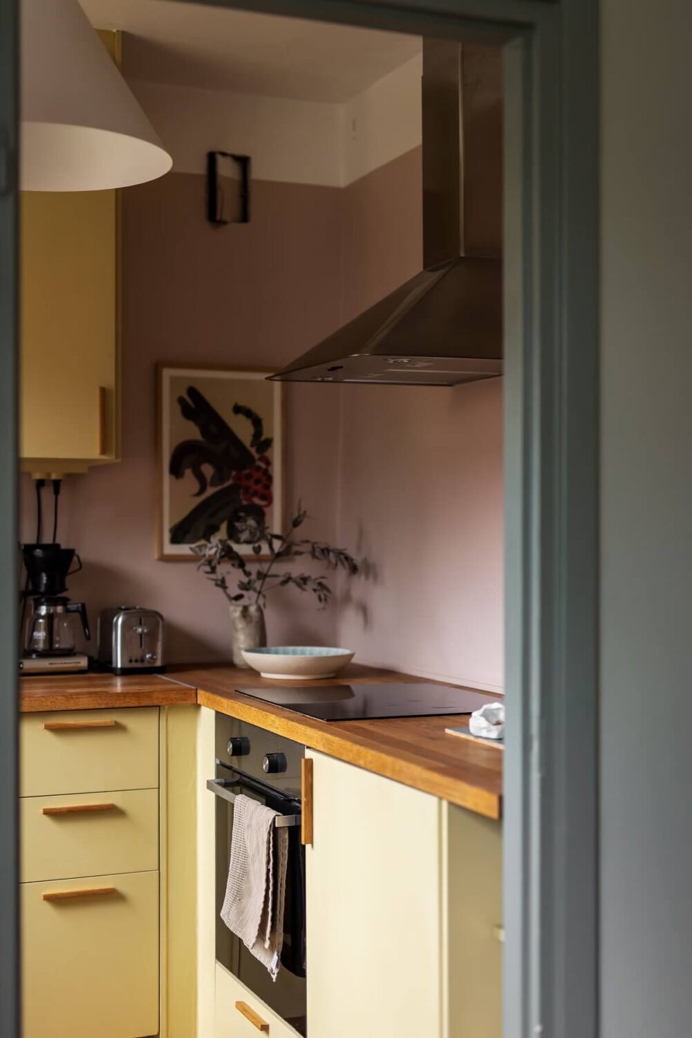 light pink walls and yellow kitchen cabinets