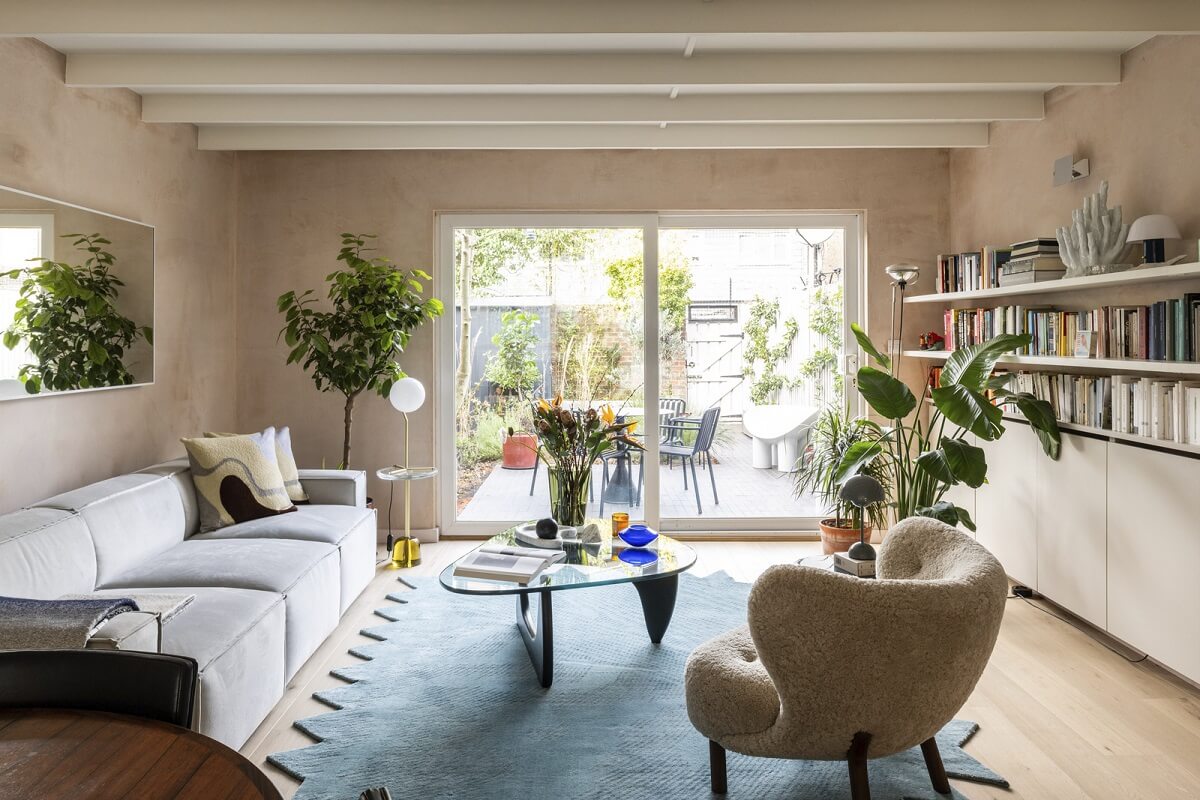 living room with plaster walls wooden beams and blue rug