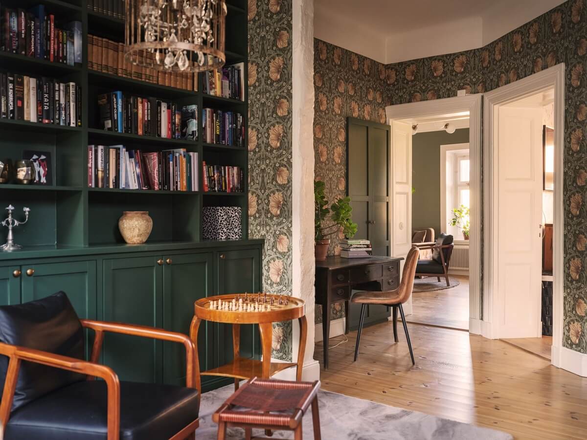 reading room with green bookcases and william morris wallpaper