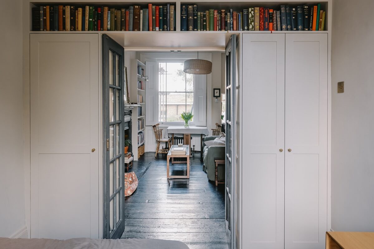 bedorom with built in wardrobes and bookshelf above the door