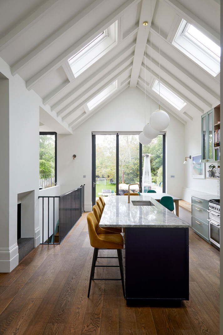 dark blue kitchen island with yellow bar stools