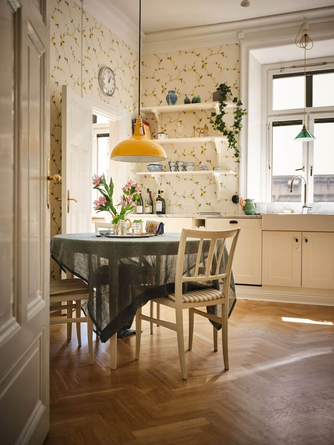 light cottage style kitchen with floral wallpaper round table and herringbone floor nordroom