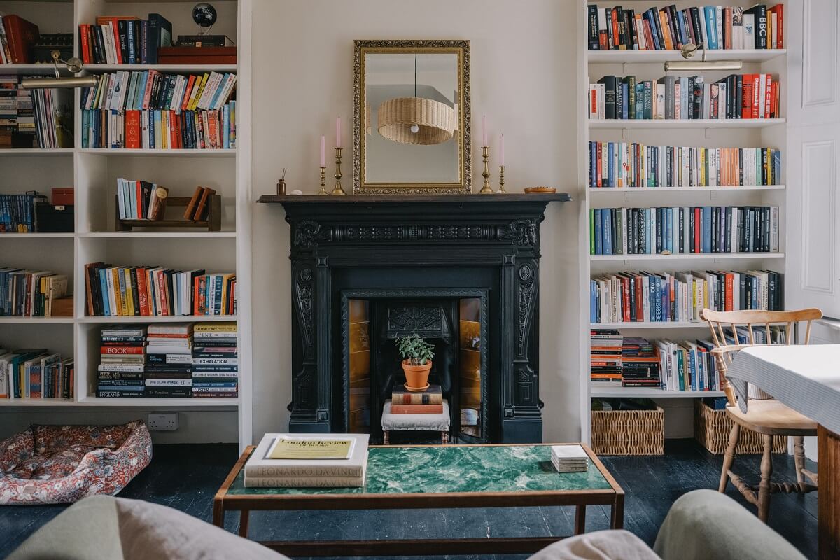 living room with black fireplace and bookshelves