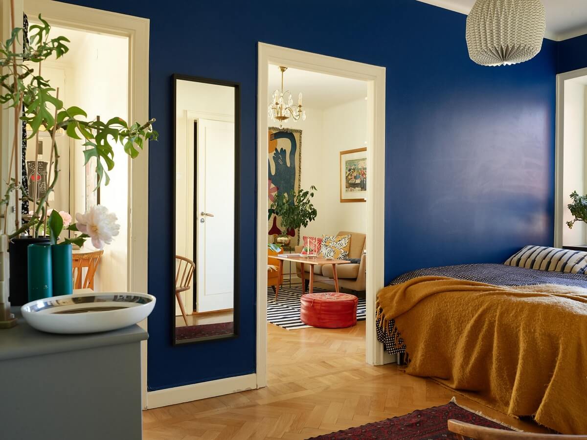 bedroom with vibrant blue walls and yellow throw nordroom