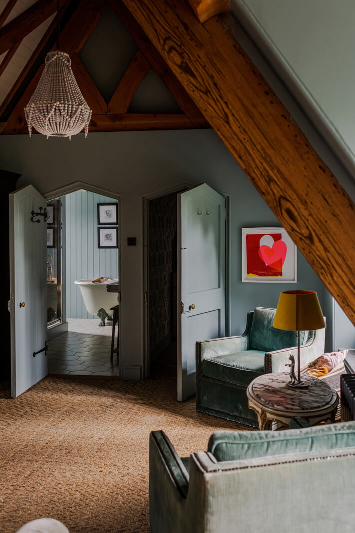 A Charming Gothic-Style Home with Original Details 29 blue attic bedroom with pitched ceiling and wooden beams nordroom