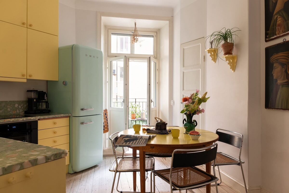 yellow kitchen with mint green smeg fridge and round table nordroom