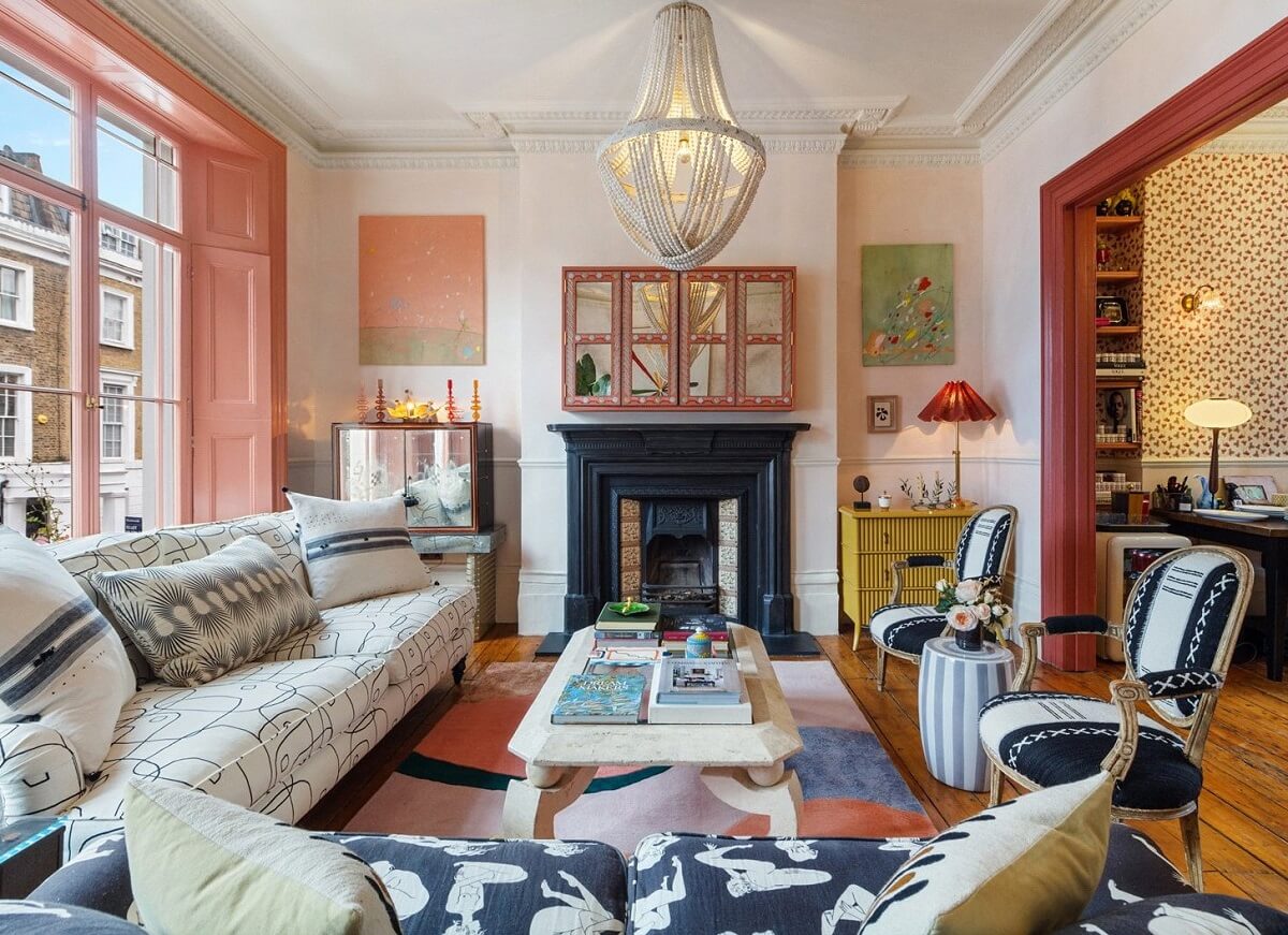 living room with black fireplace pink woodwork and graphic sofas