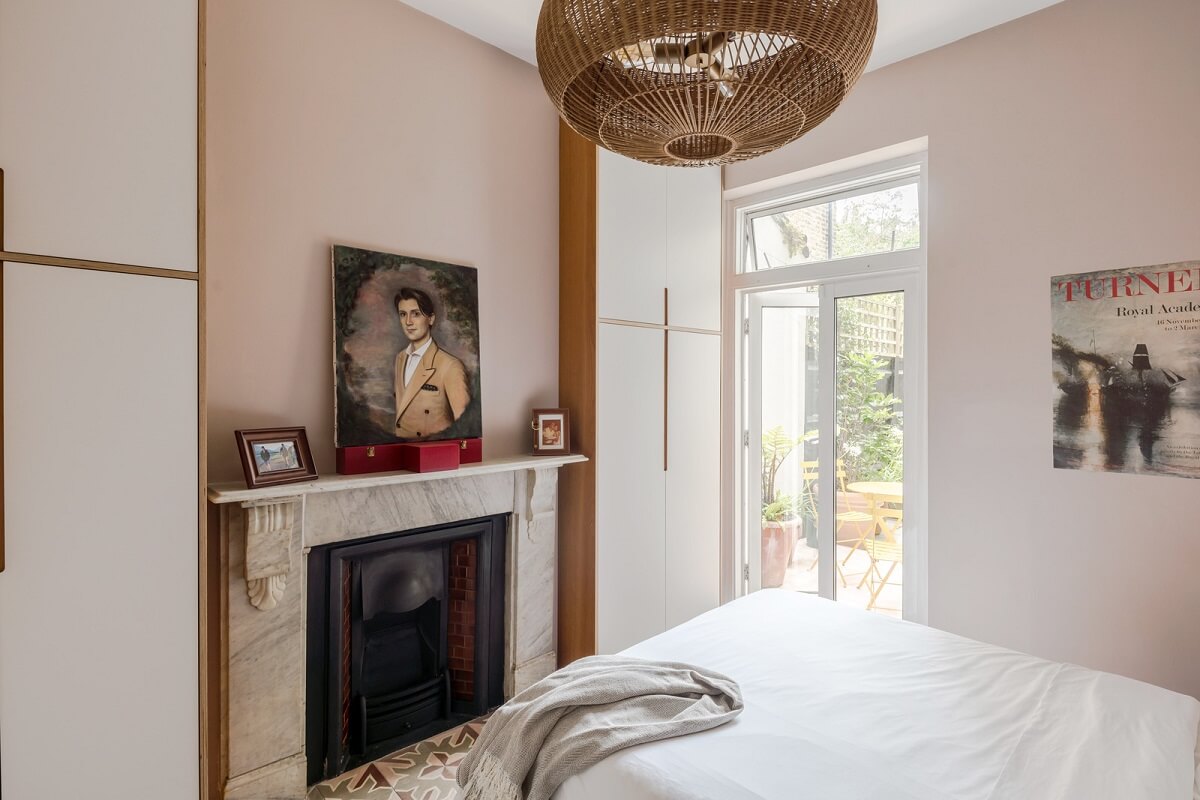 small light pink bedroom with fireplace and wardrobes nordroom