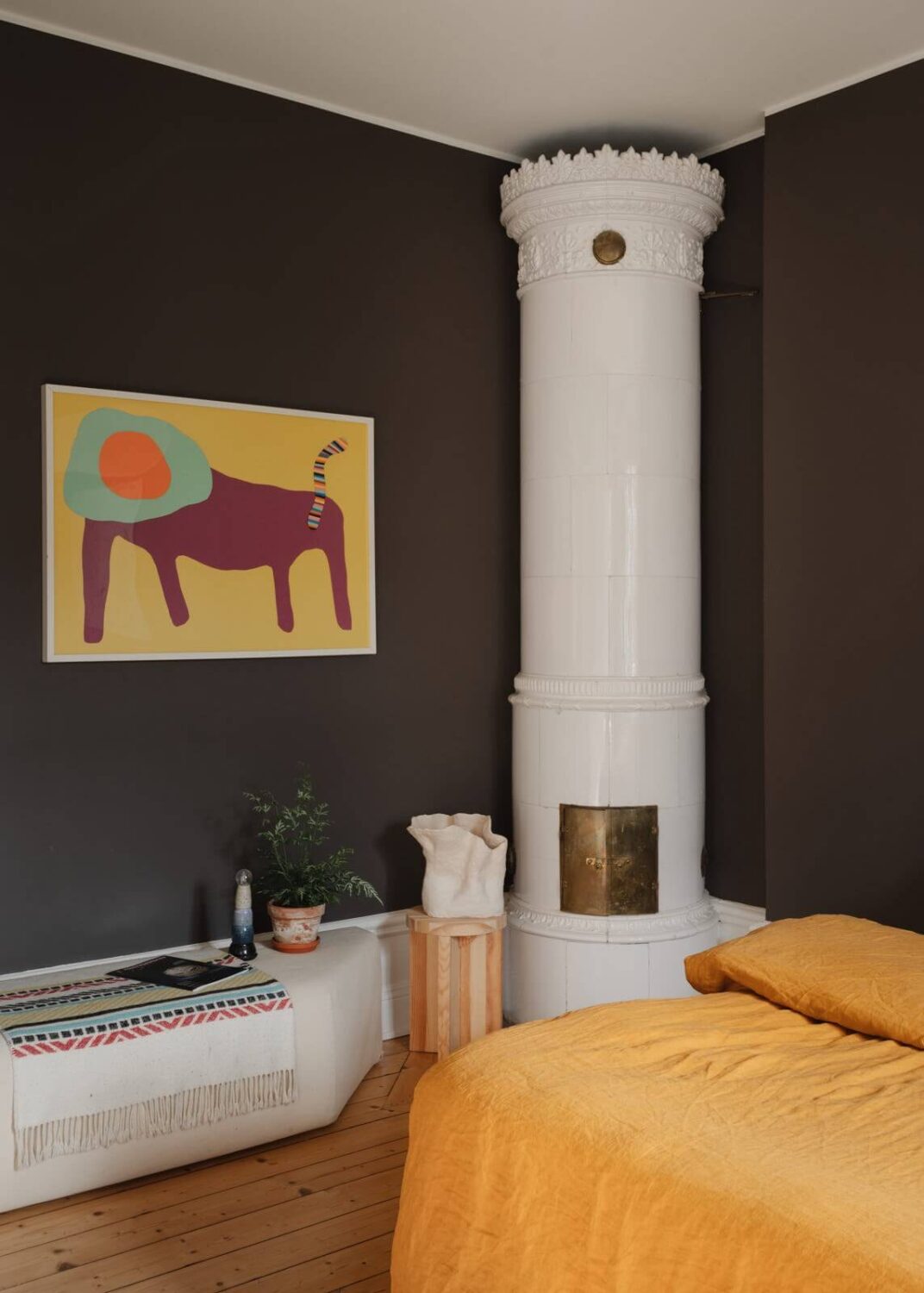 bedroom with dark plum walls fireplace and ochre yellow bedding nordroom