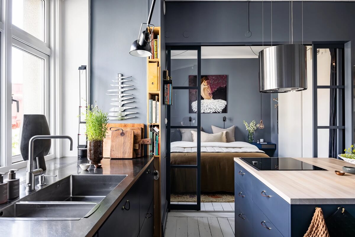 dark bedroom with steel doors to bedroom A Swedish Apartment with a Moody Kitchen and Bedroom