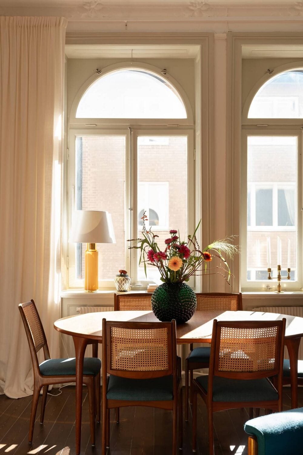 A Beautiful Turn-of-the-Century Apartment with Bold Color Accents 7 dining table with arched windows