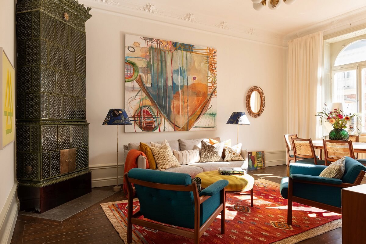 living room with green fireplace red rug and blue chairs