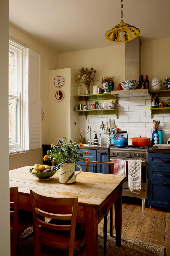 tiny cottage style kitchen with blue cabinets and green shelves nordroom