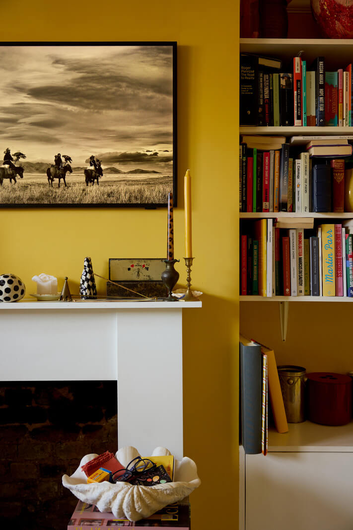 yellow living room with fireplace flanked by shelves nordroom
