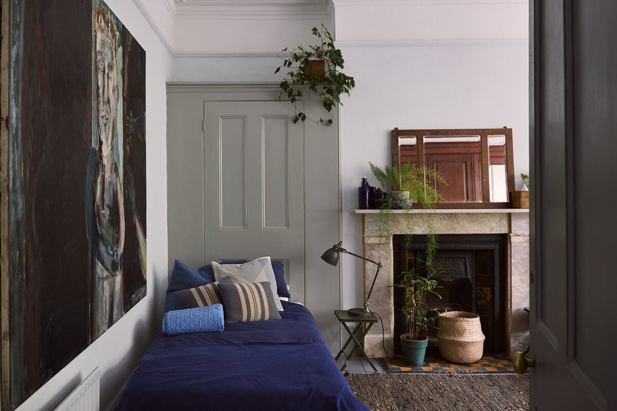 bedroom wth blue couch and fireplace