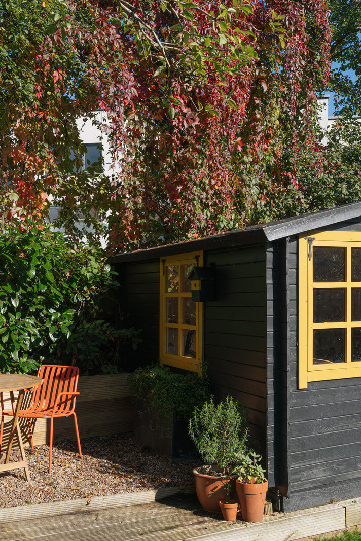 black garden shed yellow windows