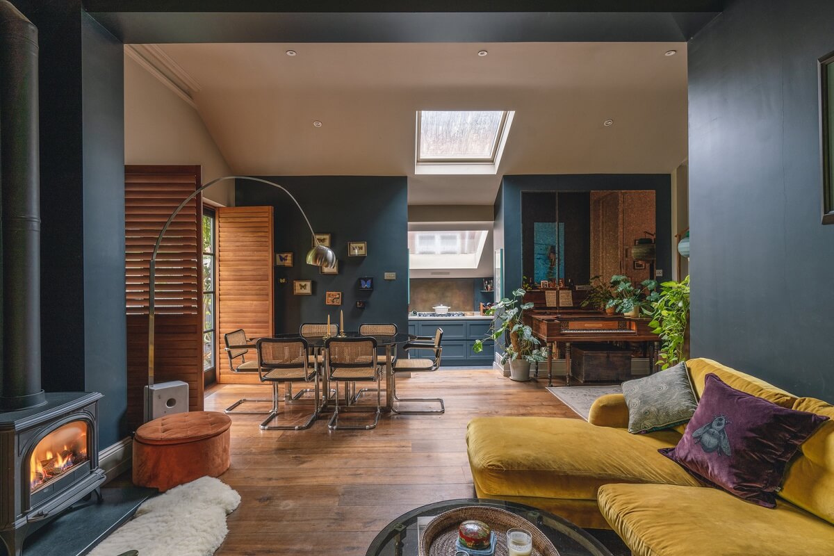 blue living room with wood burner ochre sofa and brown shutters nordroom