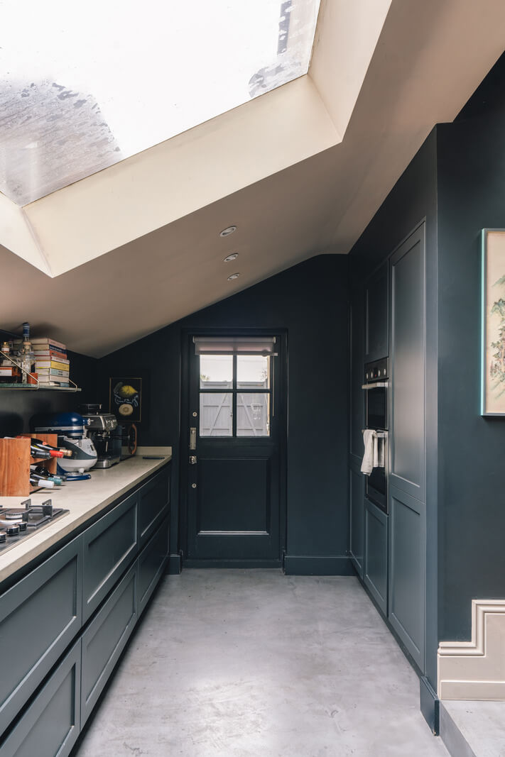 dark blue kitchen with slanted ceiling and large skylight nordroom