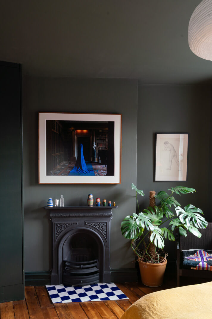dark gray bedroom with fireplace and checkerboard tiles