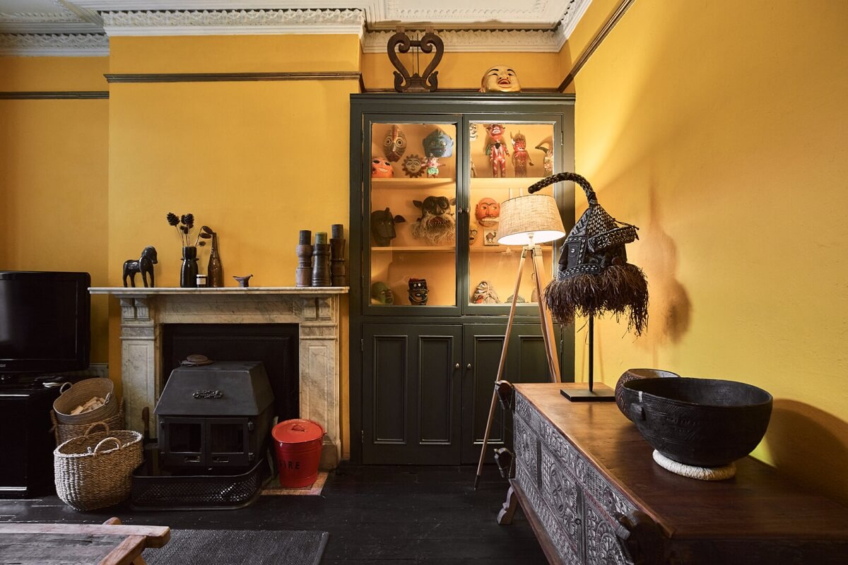 yellow sitting room with dark floor and fireplace
