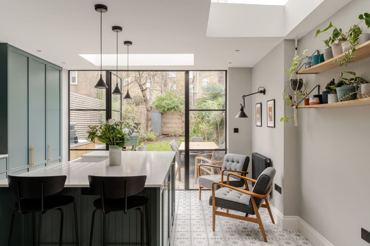 green kitchen with island and lounge chairs