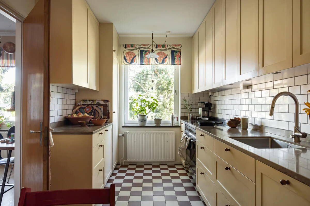 A Cozy Swedish Apartment in a 1950s Building 10 galley kitchen dark beige cabinets checkerboard floor