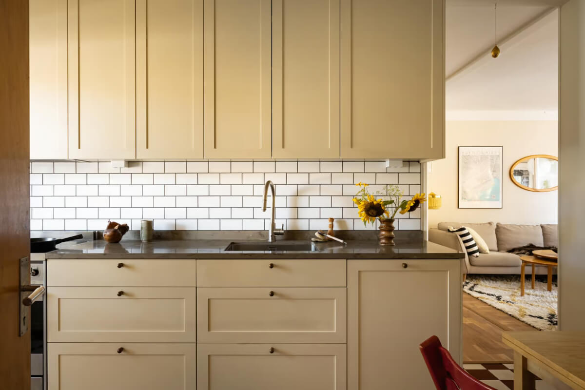 A Cozy Swedish Apartment in a 1950s Building 12 kitchen dark beige cabinets white subway tiles
