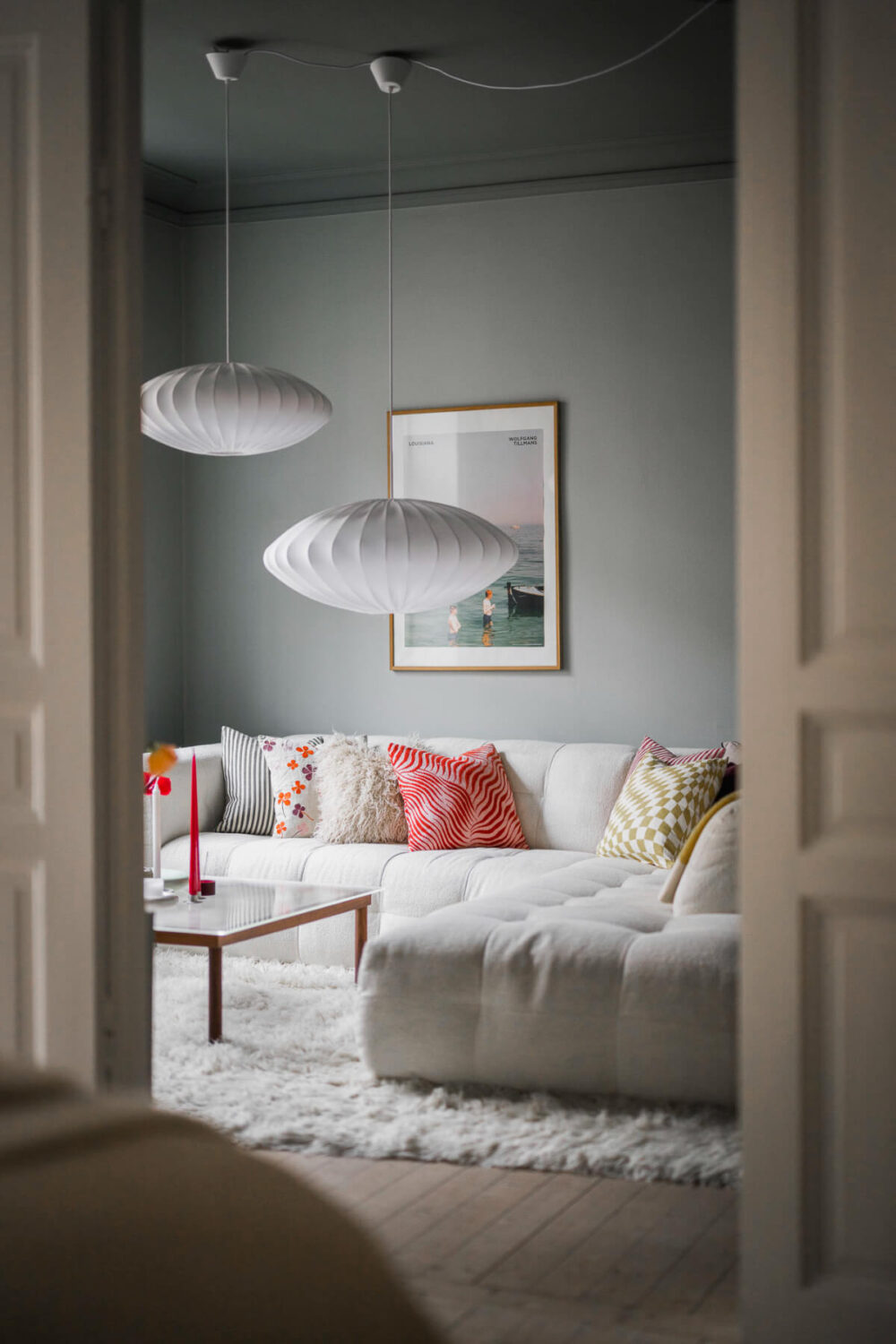 An Early 20th-Century Apartment with a Pink Kitchen 2 peek into gray living room An Early 20th-Century Apartment with a Pink Kitchen
