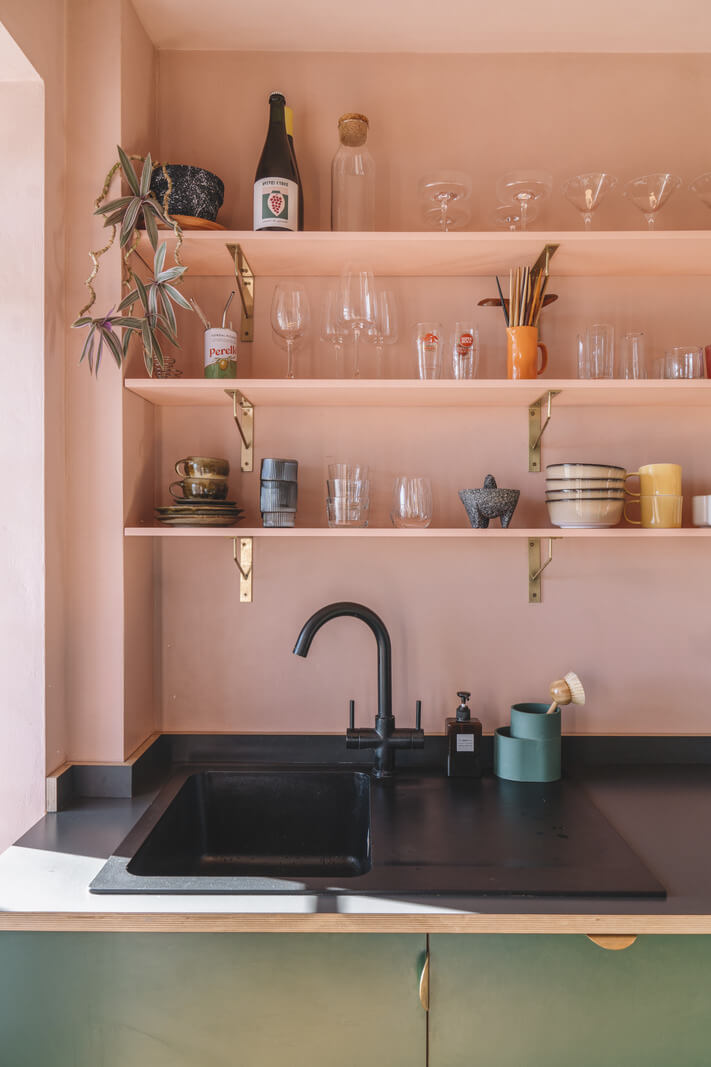 pink walls and shelves green cabinets black fittings