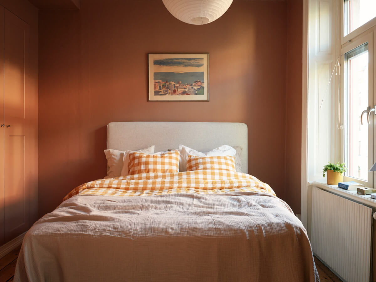 small terracotta bedroom with built-in wardrobes