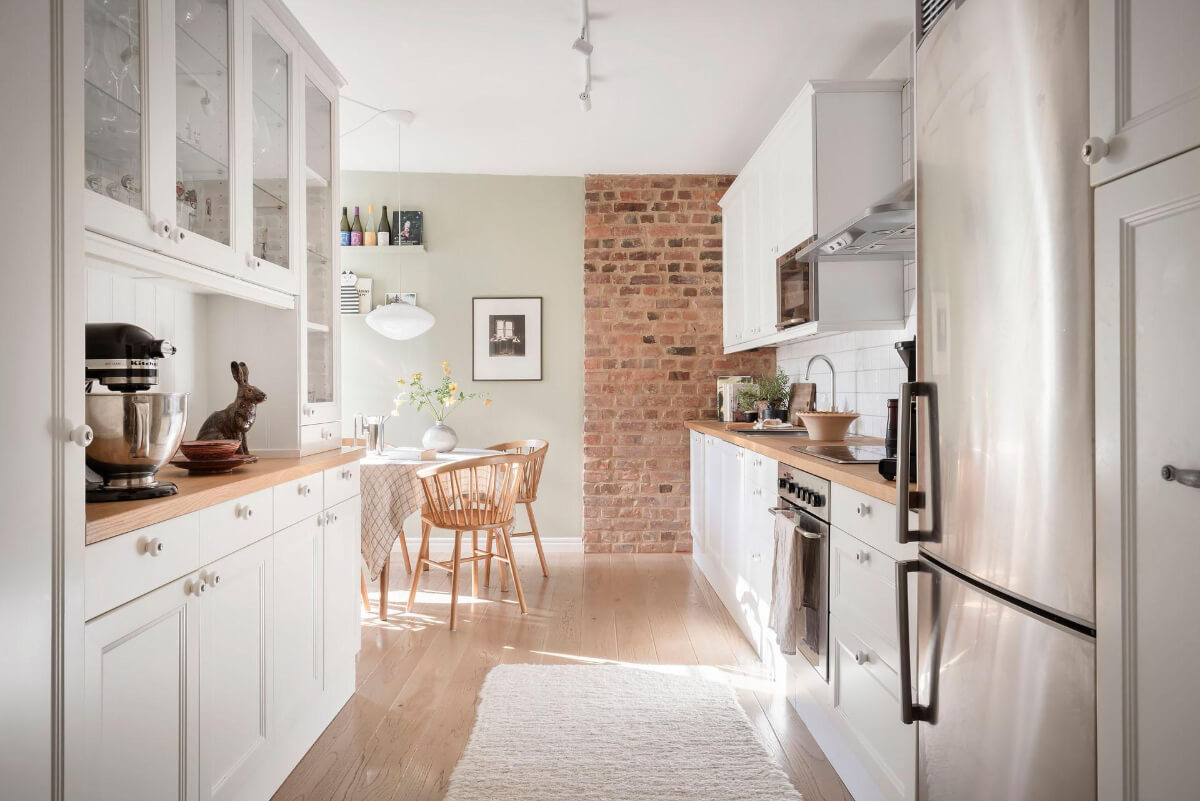 white kitchen with brick wall