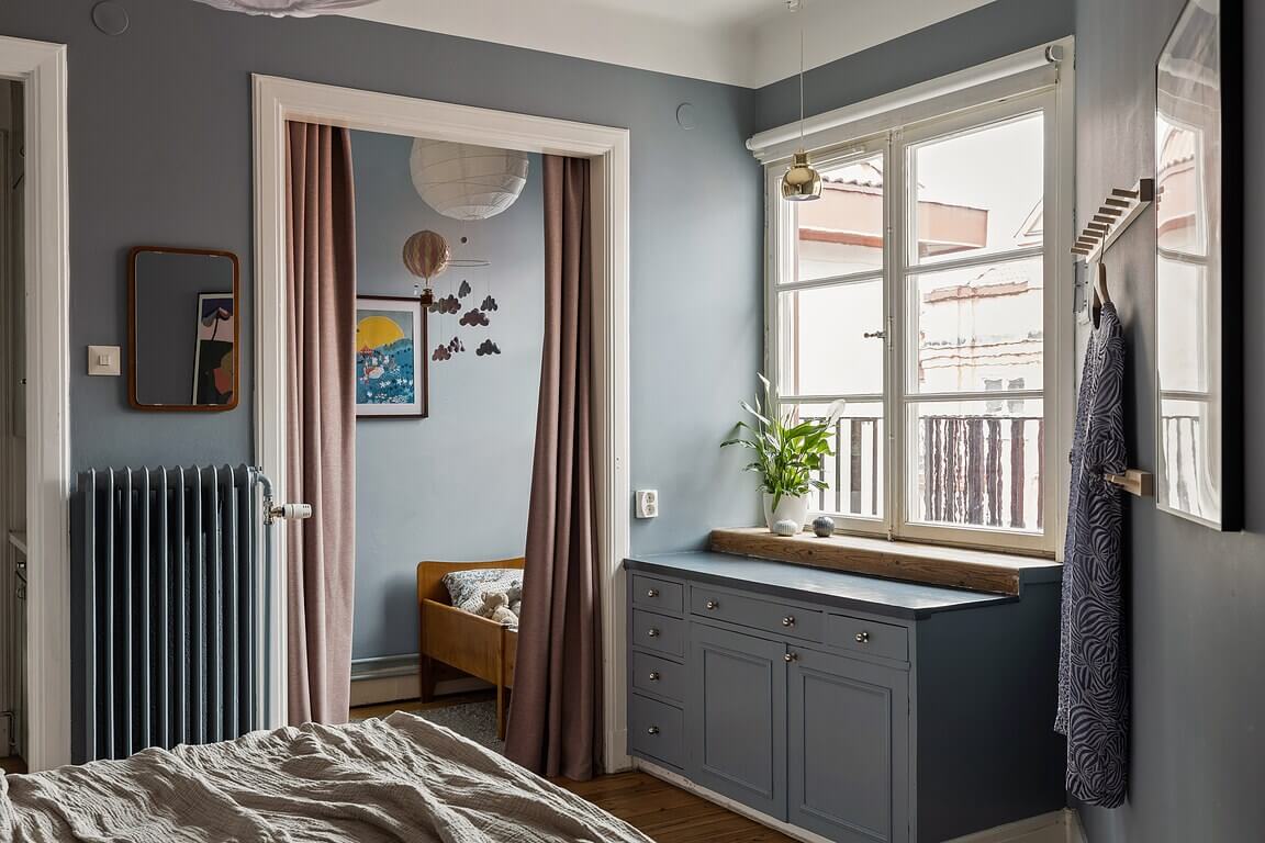 A Stockholm Apartment with a Light Yellow Kitchen 19 blue bedroom cabinets under window