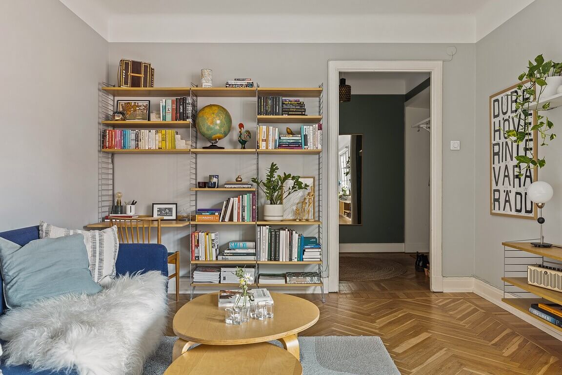A Stockholm Apartment with a Light Yellow Kitchen 1 gray living room with bookshelves and desk
