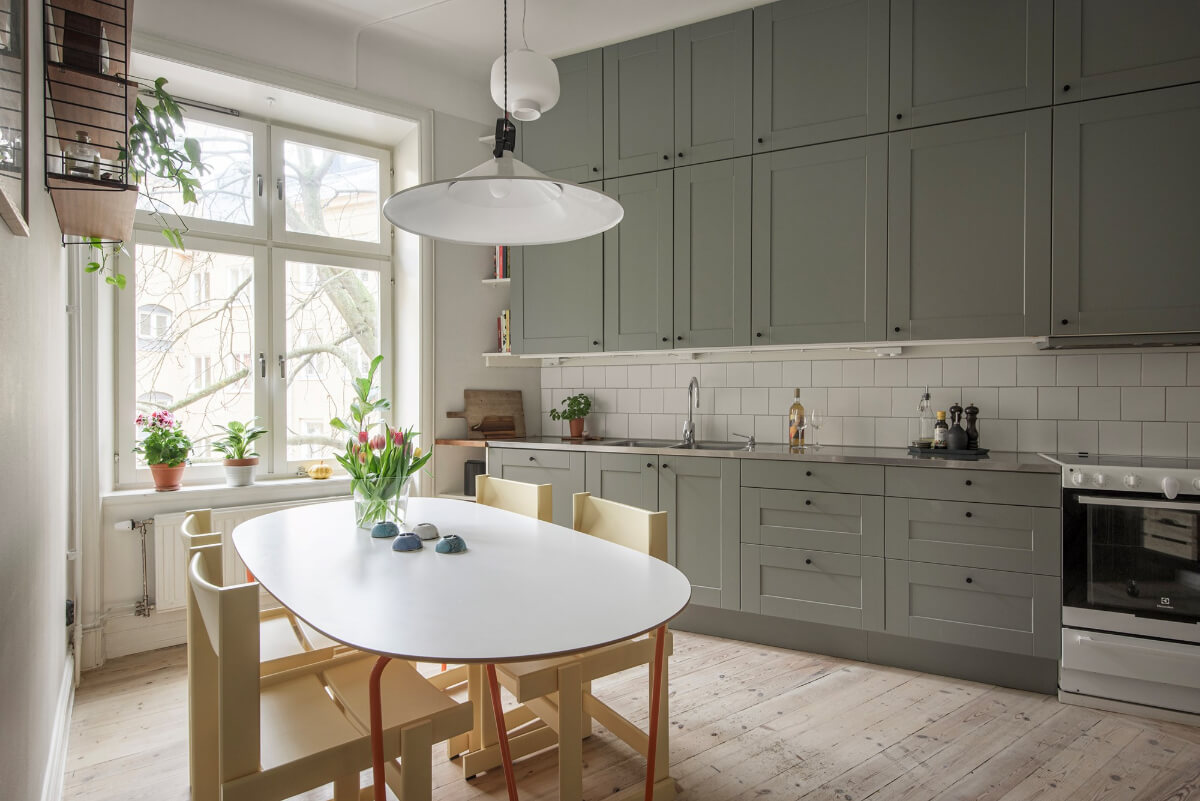 Rooms with Unique Shapes in a Lovely Swedish Apartment 13 kitchen double row upper cabinets large table