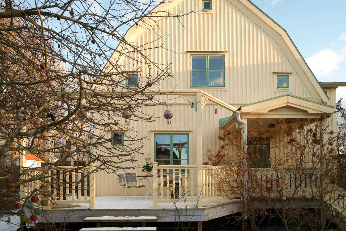 light yellow swedish house with wooden terrace