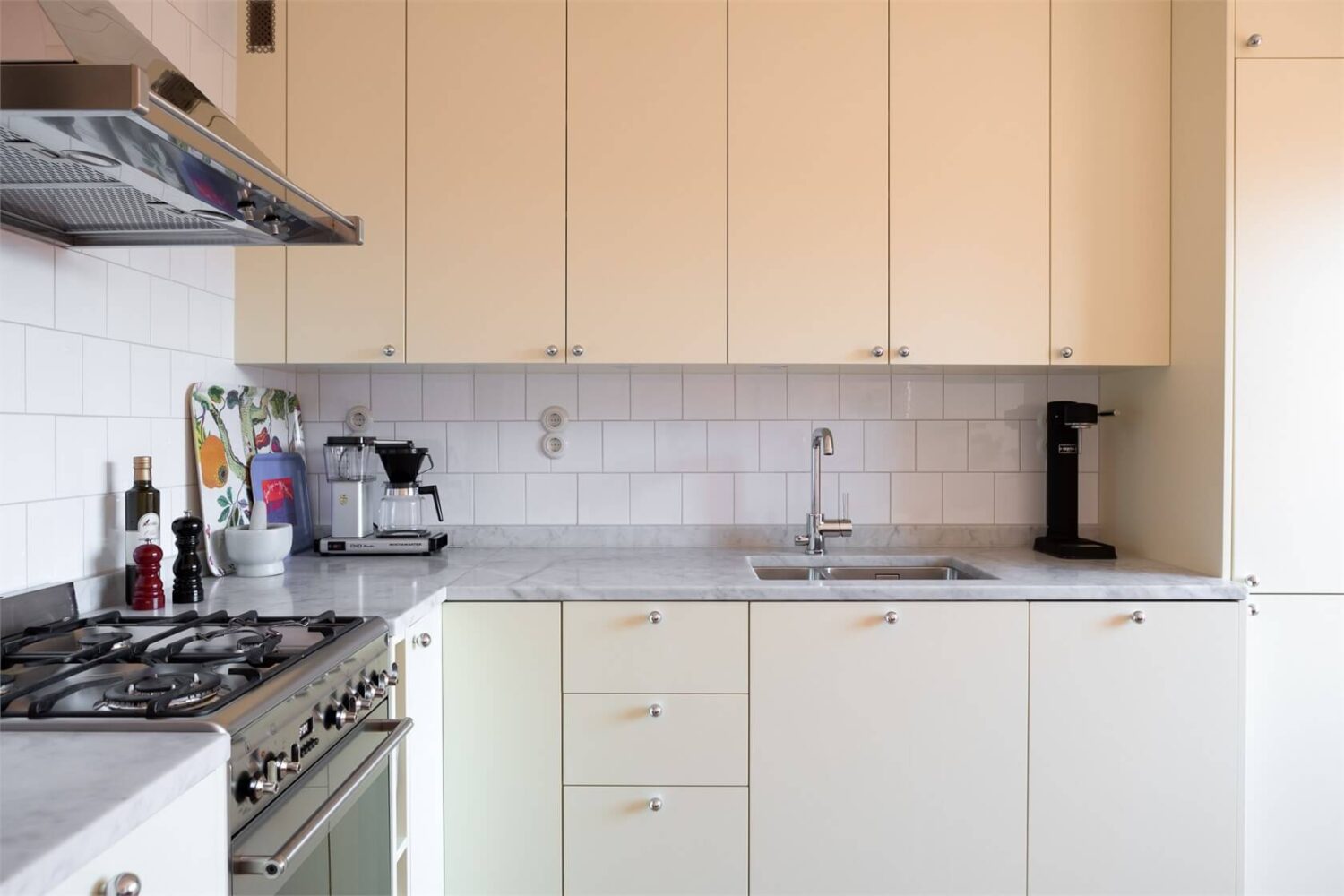 A Stockholm Apartment with a Light Yellow Kitchen 8 pale yellow kitchen cabinets marble countertop