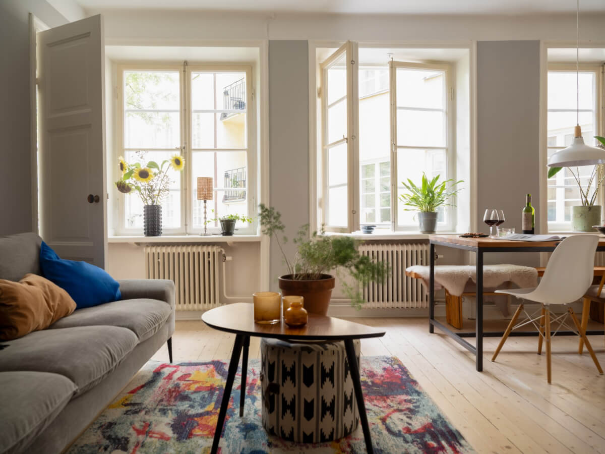 three large windows open plan living space wooden floor A Charming One-Bedroom Apartment in a 1920s Building