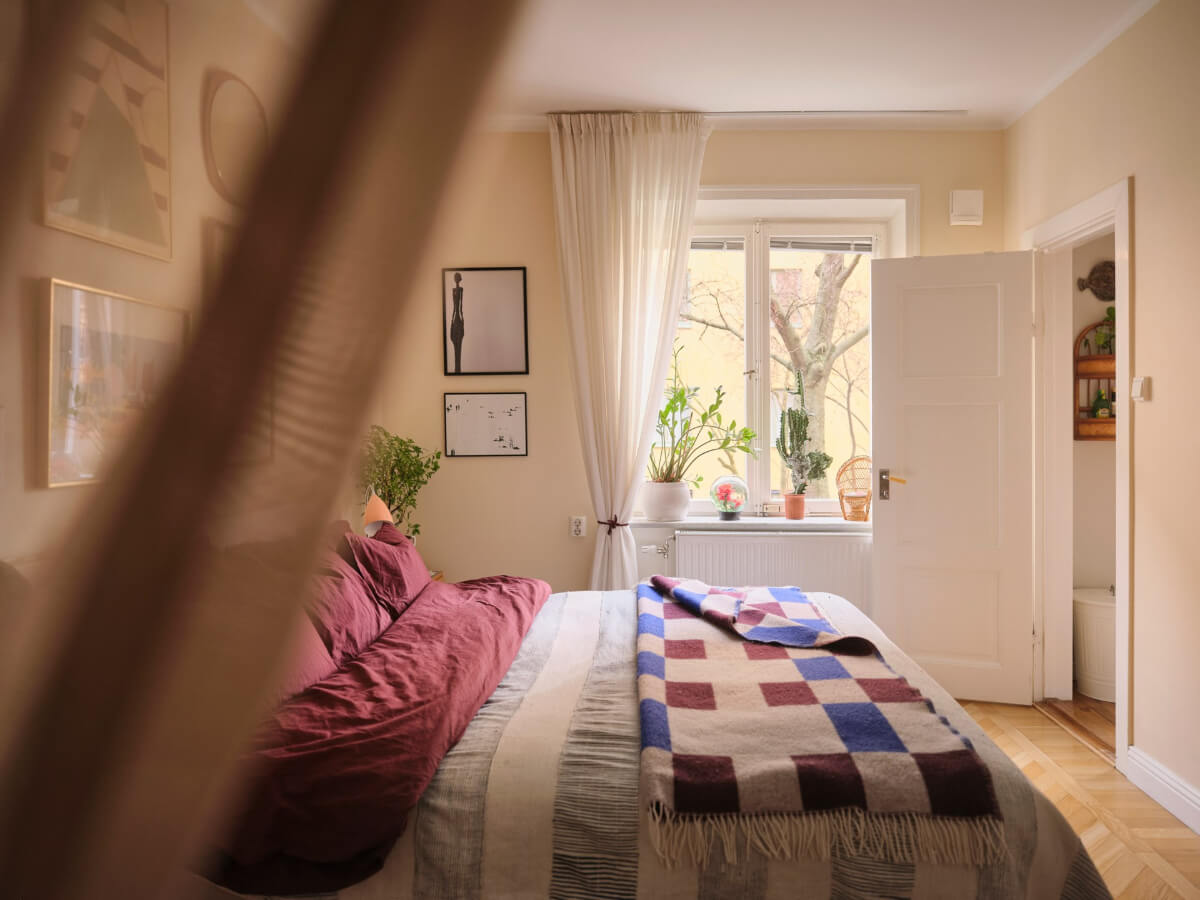 A Corner Apartment with Period Features and Bright Color Pops 14 bedroom beige-yellow walls parquet floor colorful textiles and art