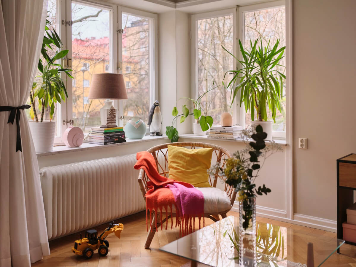 A Corner Apartment with Period Features and Bright Color Pops 4 corner window with rattan chair