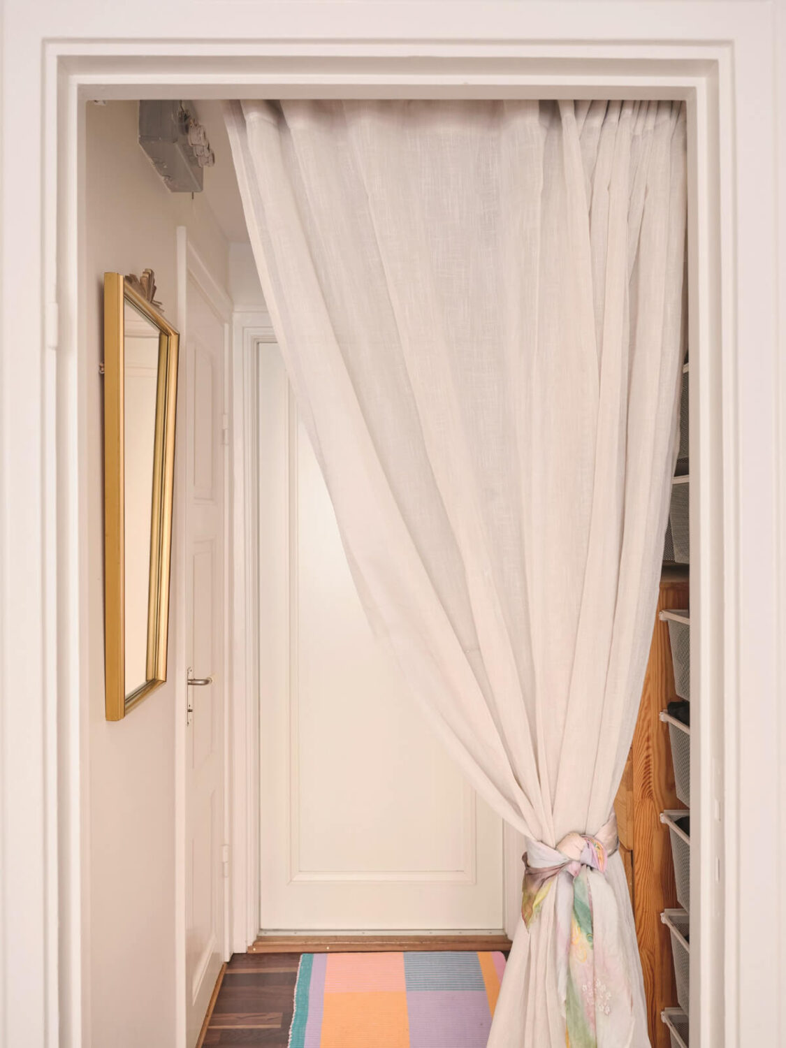 A Corner Apartment with Period Features and Bright Color Pops 15 doorway with curtain