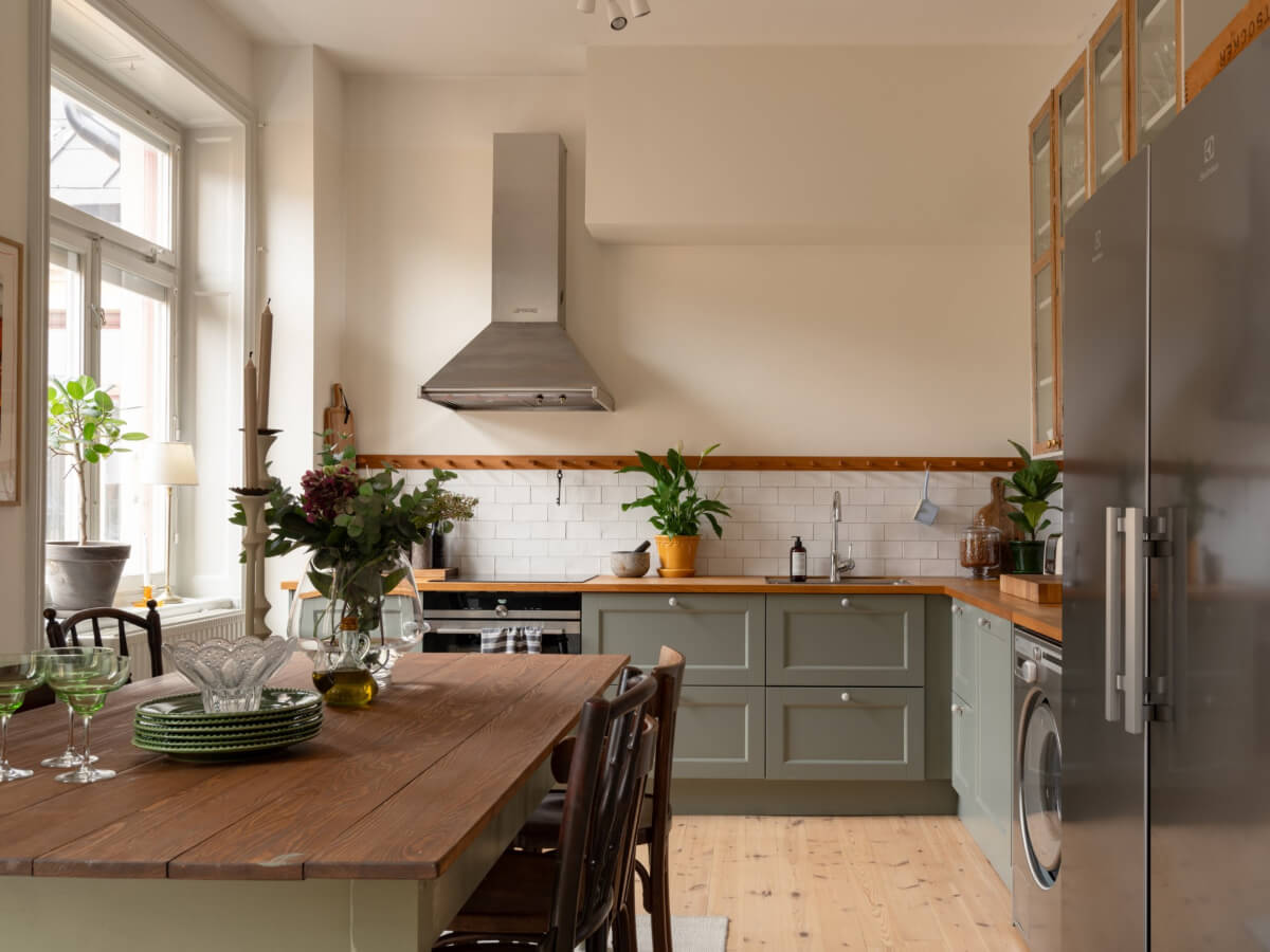 Soft Color Tones in a Renovated Turn-of-the-Century Apartment 6 green kitchen white backsplash tiles